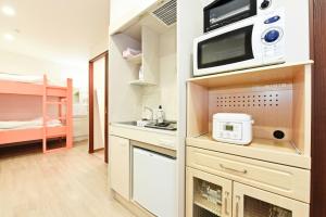 a small kitchen with a microwave and a bunk bed at Heights N7 / Vacation STAY 7569 in Sapporo