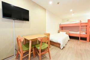 a room with a table and chairs and a bed at Heights N7 / Vacation STAY 7569 in Sapporo