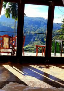 une porte ouverte sur une terrasse couverte offrant une vue sur la montagne. dans l'établissement Oxy Breeze Ella, à Ella