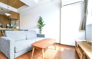 een woonkamer met een bank en een tafel bij Hills Garden Hondori / Vacation STAY 7583 in Sapporo