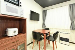 a room with a table and two chairs and a microwave at Heights N7 / Vacation STAY 7573 in Sapporo