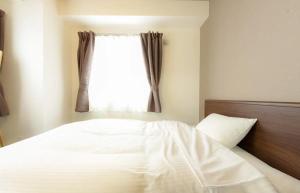 a bedroom with a white bed and a window at Suncourt Minami 6jo Nibankan / Vacation STAY 7447 in Sapporo