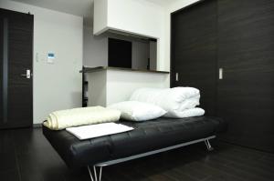 a black leather couch with white pillows on it at Suncourt Maruyama Goden Hills / Vacation STAY 7605 in Sapporo