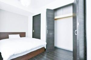 1 dormitorio con 1 cama y puerta corredera de cristal en Suncourt Hondori Garden Hills / Vacation STAY 7593 en Sapporo