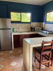 eine Küche mit einem Kühlschrank sowie einem Tisch und Stühlen in der Unterkunft Casitas Joys & Leo - Rana in Santa Rita