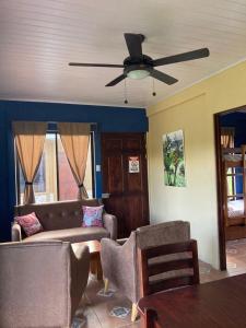 a living room with a couch and a ceiling fan at Casitas Joys & Leo - Rana in Santa Rita