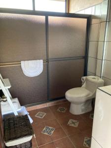 a bathroom with a toilet and a shower stall at Casitas Joys & Leo - Rana in Santa Rita