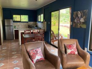 ein Wohnzimmer mit 2 Stühlen und eine Küche in der Unterkunft Casitas Joys & Leo - Rana in Santa Rita