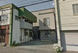 a house with a garage next to a building at Hongo Street House - Vacation STAY 8636 in Sapporo