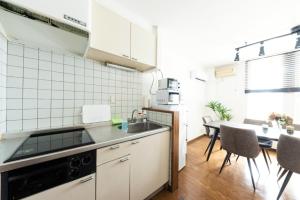 a kitchen with a sink and a table with chairs at Hongo Street House - Vacation STAY 8636 in Sapporo