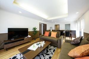 uma sala de estar com um sofá e uma televisão de ecrã plano em Dynasty Palace Nijyuuyonken / Vacation STAY 7377 em Sapporo