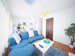 a living room with a blue couch and a table at Sapporo - Apartment - Vacation STAY 7940 in Sapporo