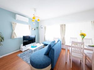 ein Wohnzimmer mit einem blauen Sofa und einem Tisch in der Unterkunft Sapporo - Apartment - Vacation STAY 7940 in Sapporo