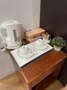 a table with a coffee maker and a box on it at Samudera Hotel in Kampung Kuala Besut