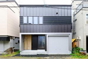 ein modernes Haus mit einer weißen Garagentür in der Unterkunft D plus one doors - Vacation STAY 88116 in Otaru