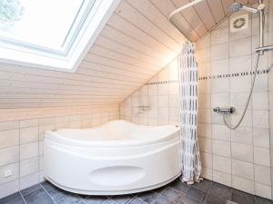 a bathroom with a white tub and a shower at 6 person holiday home in Nørre Nebel in Nørre Nebel +28 photos