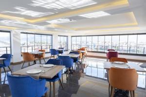 a dining room with tables and chairs and windows at ES TERMAL OTEL&SPA in Derekoy