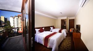 una camera d'albergo con due letti e un balcone di Karma Hotel Nepal a Kathmandu Altre 26 foto