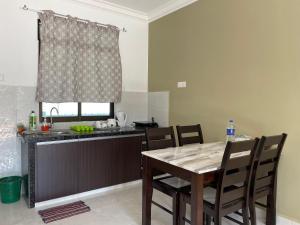 a kitchen with a table and chairs and a sink at Laura Guest House Langkawi in Pantai Cenang