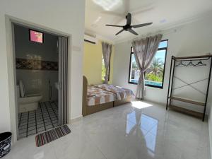 a bedroom with a bed and a bathroom at Laura Guest House Langkawi in Pantai Cenang