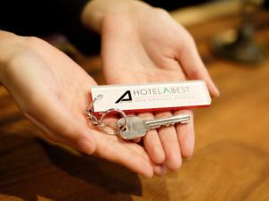 a person holding a pair of scissors in their hands at Hotel Abest Osu Kannon Ekimae Hane no Yu in Nagoya