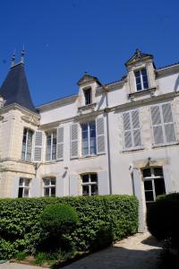 un gran edificio blanco con ventanas y techo en Le Villemarais, site d'exception en La Rochelle