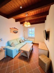 uma sala de estar com um sofá azul e uma mesa em 2 Zimmer Business Wohnung mit Terrasse em Ahrensburg