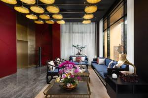 廣州的住宿－广州永庆坊瞻云精选酒店，客厅配有蓝色的沙发和带鲜花的桌子