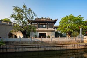 um edifício junto a um rio junto a uma ponte em The Yun Collection Guangzhou Yong Qing Fang em Guangzhou