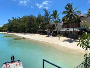 a boat in the water next to a beach at Grand Baie Seaview Penthouse in Grand-Baie