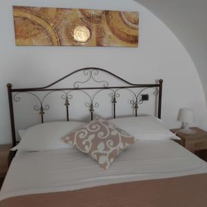 a bedroom with a bed with a picture on the wall at Dimora Margherita in Matera