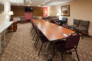 una sala de conferencias con una mesa larga y sillas en AmericInn by Wyndham Austin, en Austin