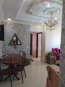 Un comedor con una mesa y una lámpara de araña. en حدائق إفران, en Ifrane