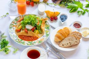 a white table with a plate of food and bread at Hotel Stelle Belle in Hakuba