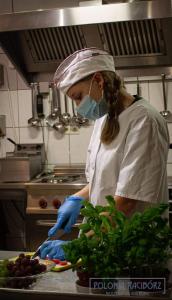 a woman in a kitchen preparing food in a kitchen at Polonia Raciborz in Racibórz