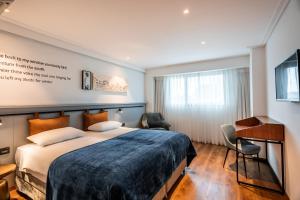 um quarto de hotel com uma cama e uma secretária em Roxon Urban Ramat Gan em Ramat Gan