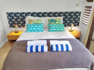 a large bed with blue and white pillows on it at Palm Cove Beach Retreat - 1st Floor in Palm Cove