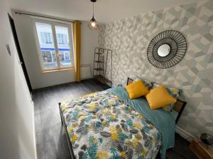 Schlafzimmer mit einem Bett, einem Spiegel und einem Fenster in der Unterkunft Parking - Wifi - Hyper Centre - Cosy - Lumineux in Montivilliers