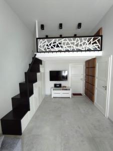 un salon avec un escalier noir et blanc dans l'établissement Apartament w stylu loft, à Jelenia Góra