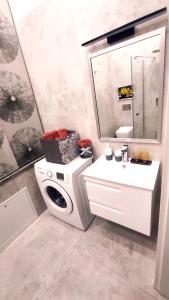 La salle de bains est pourvue d'un lave-linge et d'un lavabo. dans l'établissement Apartament w stylu loft, à Jelenia Góra
