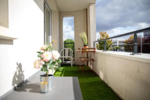 een balkon met een tafel en bloemen bij LES 2 LIONS moderne confort proche transports in Tours