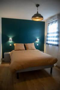a bedroom with a large bed with a green headboard at LES 2 LIONS moderne confort proche transports in Tours