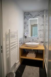 W łazience znajduje się umywalka i lustro. w obiekcie LES 2 LIONS moderne confort proche transports w Tours