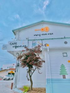 un bâtiment blanc avec un panneau sur son côté dans l'établissement Jarasum Guest House, à Gapyeong