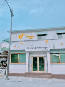 un bâtiment blanc avec des écrits chinois sur son côté dans l'établissement Jarasum Guest House, à Gapyeong