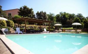 a swimming pool with chairs and a gazebo at Agriturismo Il Quarto in Manciano