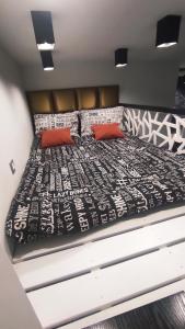 - un lit avec des draps noirs et blancs et des oreillers rouges dans l'établissement Apartament w stylu loft, à Jelenia Góra