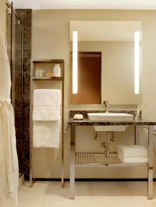 y baño con lavabo, espejo y toallas. en The Moonrise Hotel, en Saint Louis