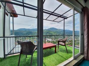balcone con tavolo rosso e 2 sedie di The SkyDeck Kandy a Kandy