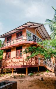 a house with a balcony on the side of it at Sarada Beach Resort in Tissamaharama